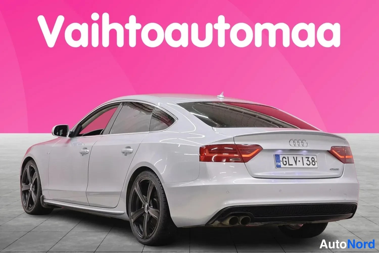 Takaviisto: Hopeanvalkoisen Audi Sportbackin takakulma, rekisterikilpi.