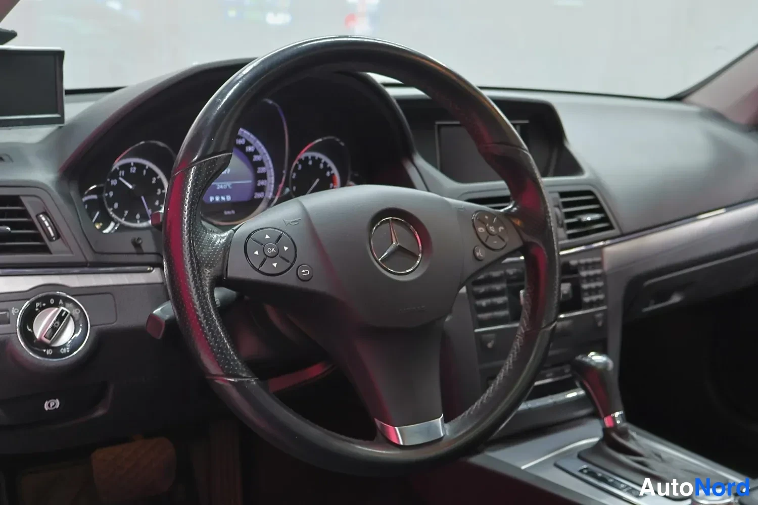 Muu: Ohjauspyörän ja kojelautan lähikuva Mercedes-Benzin sisätiloissa.