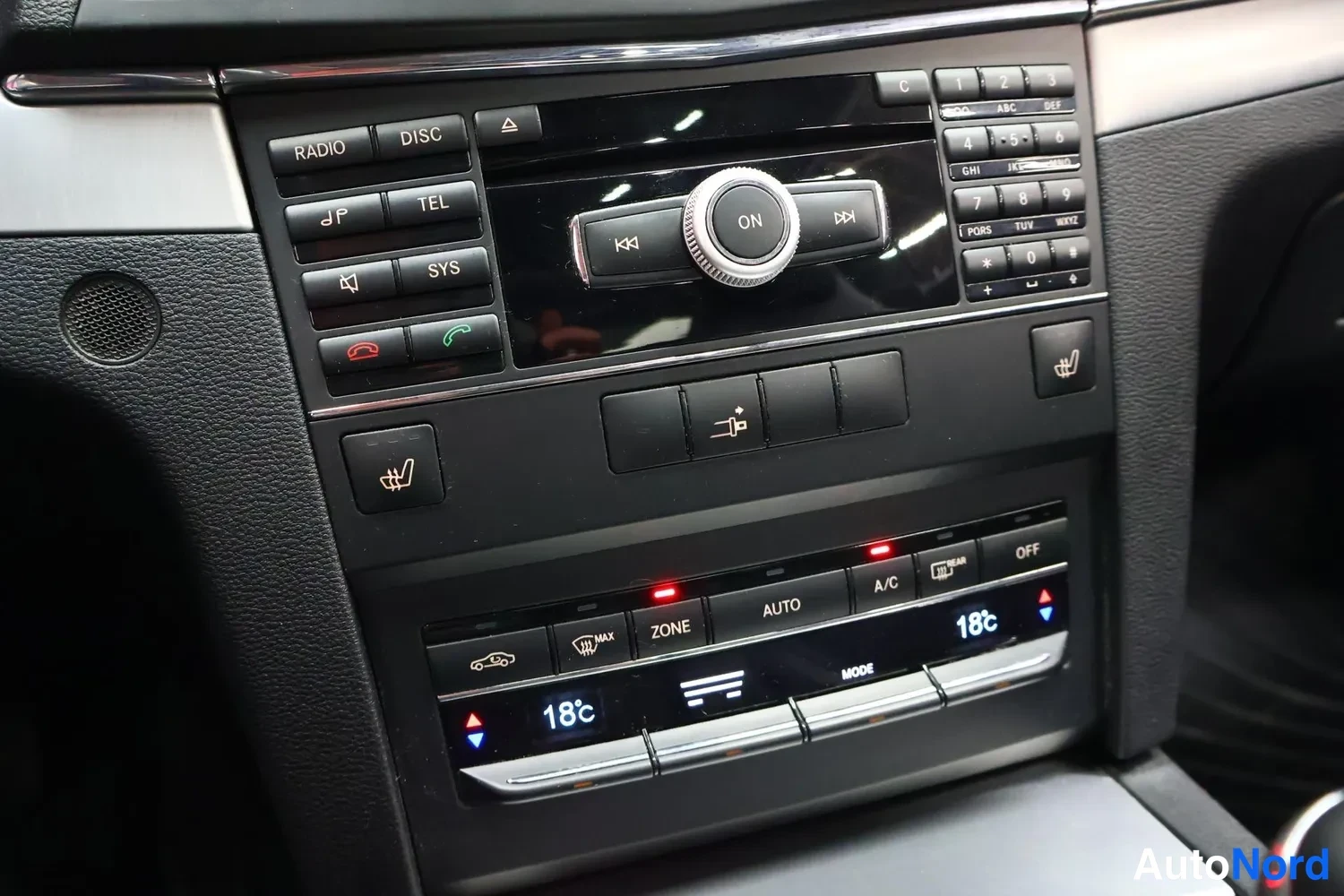 Muu: Kesäkartion hallintapaneeli: radio- ja puhelinpainikkeet, COMAND-ohjain, lämmityspainikkeet ja kaksivyöhykeilmastointi (18 °C molemmilla puolilla).