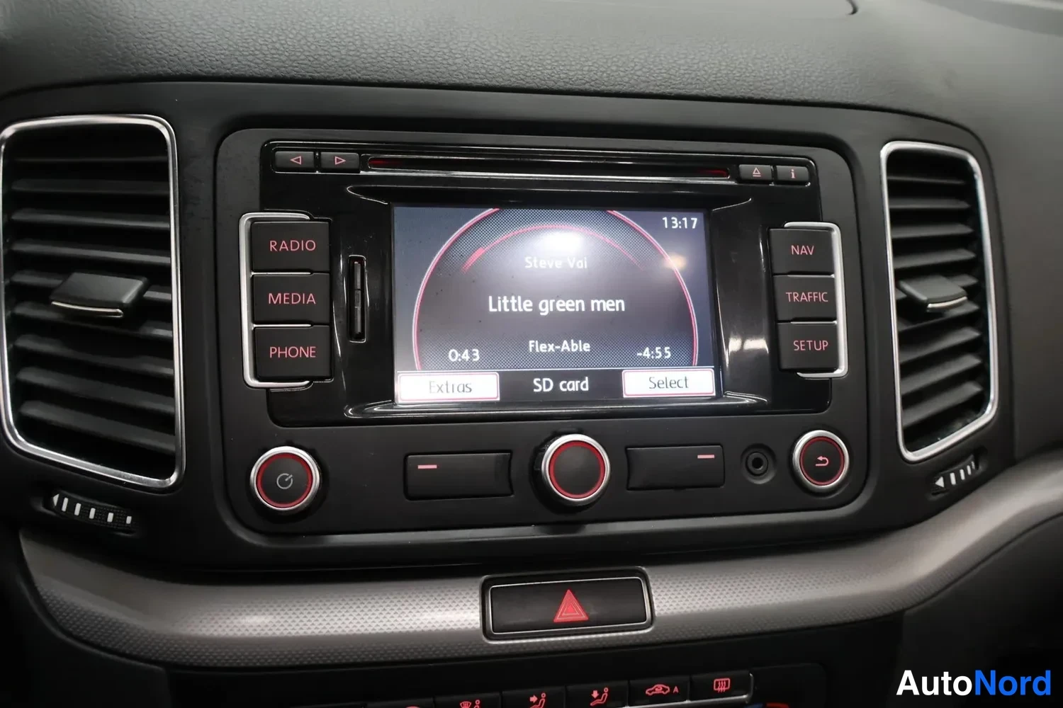 Yksityiskohta: Radionäyttö SD-kortin musiikkinäytöllä, Steve Vai: 'Little green men', aikakoodi 13:17; painikkeet Radio, Media, Phone, Nav, Traffic, Setup.
