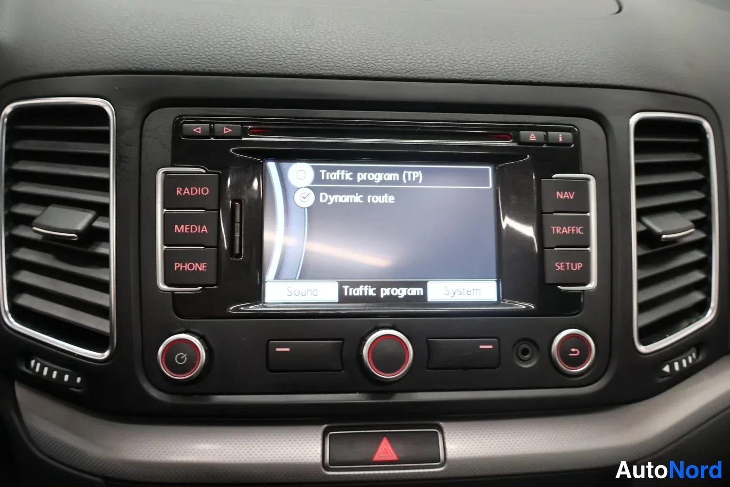 Muu: Kojelaudan keskiössä radiopaneeli ja näyttö, jossa valittuna Traffic program (TP) ja Dynamic route; painikkeet RADIO, MEDIA, PHONE, NAV, TRAFFIC ja SETUP.