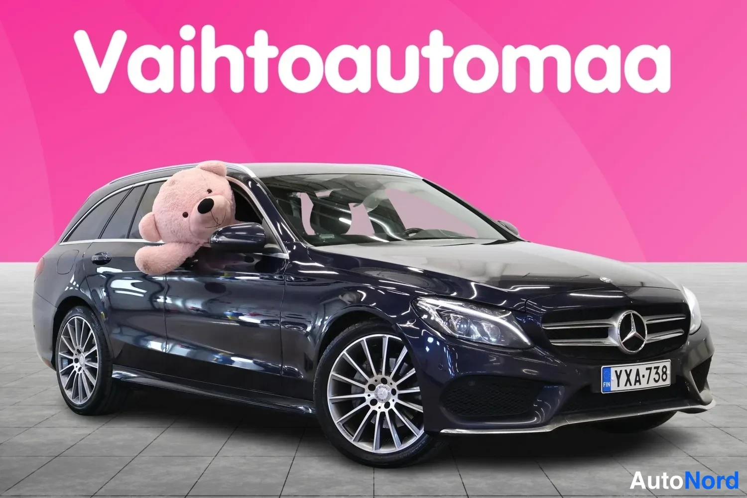 Etuviisto, nokka oikealle: Mercedes-Benz C-asemaomini etukulmasta, tummansininen koriväri, rekisterikilpi.
