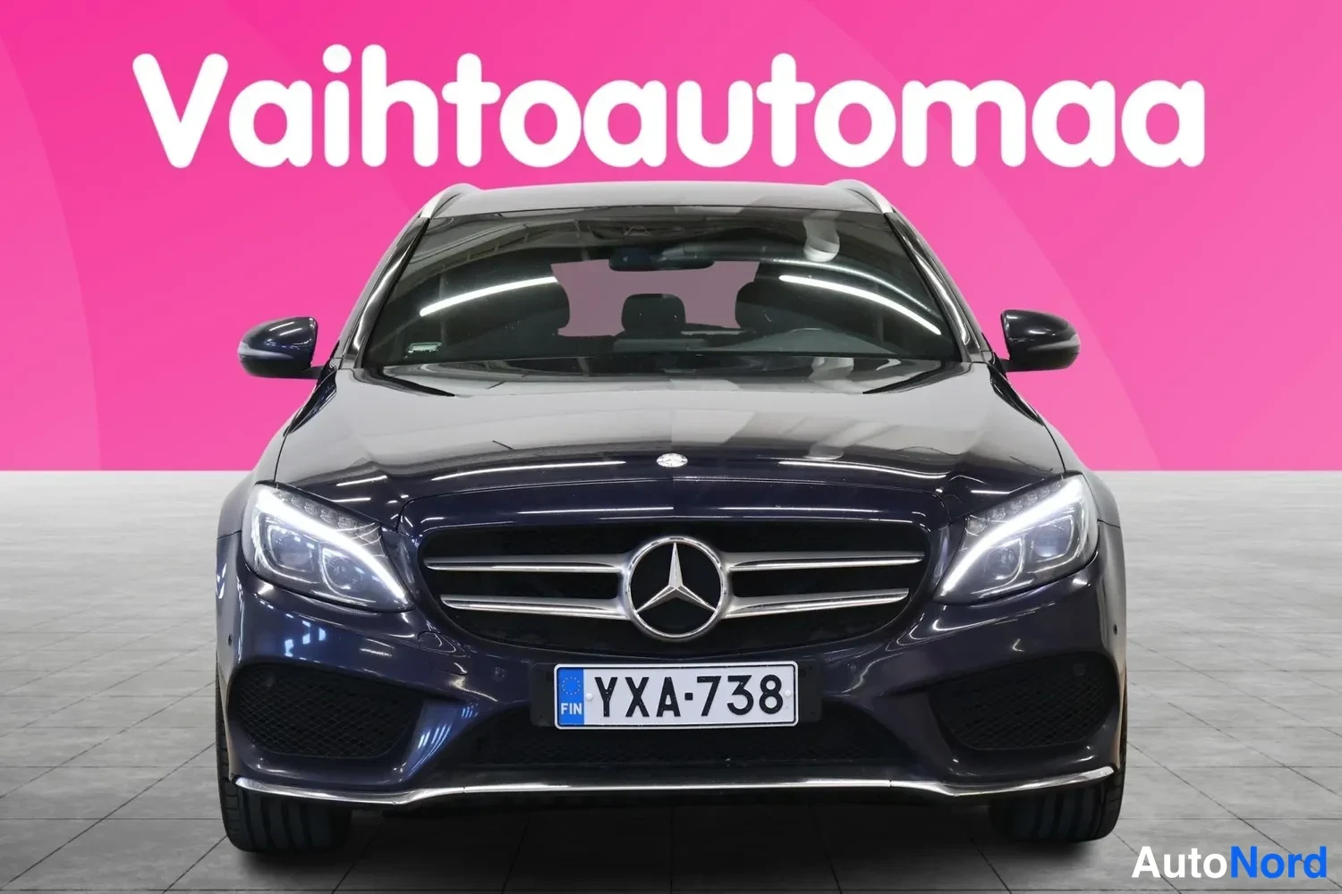 Edestä: Mercedes-Benz C-asemaomini edestäpäin, tummansininen koriväri, rekisterikilpi.