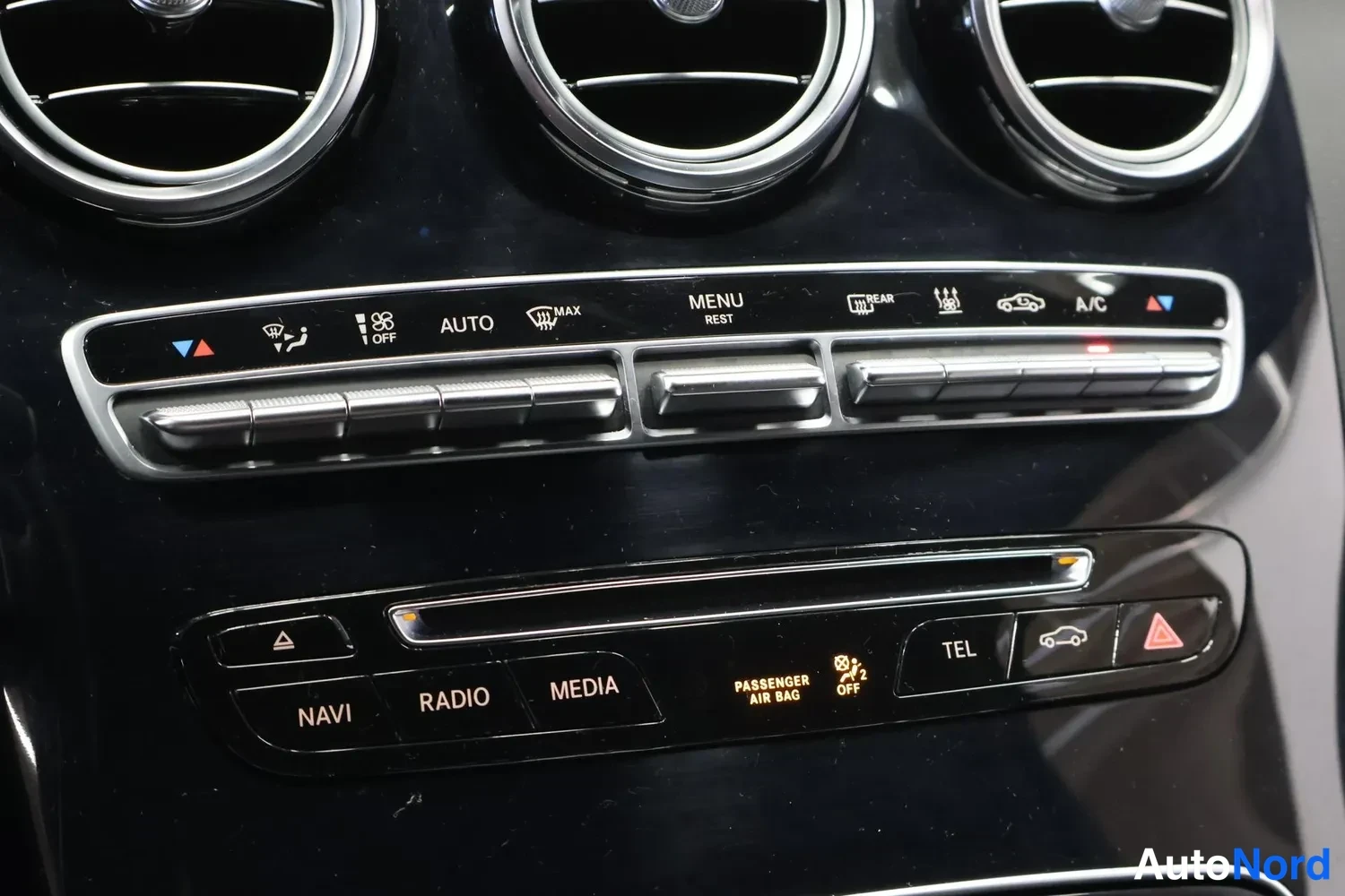 Muu: Kojelaudan keskiosan painikkeet: NAVI, RADIO, MEDIA ja TEL, ilmastoinnin AUTOMAATTI-, MAX- ja A/C-painikkeet sekä kolme pyöreää ilmastointisuutinta.