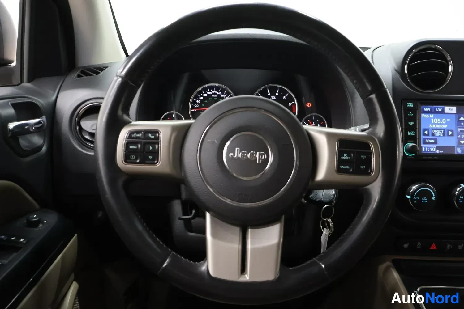 Muu: Jeep-ohjauspyörä, kojelautamittarit ja radiopaneeli, jossa näkyy kuva 105.0 MHz.
