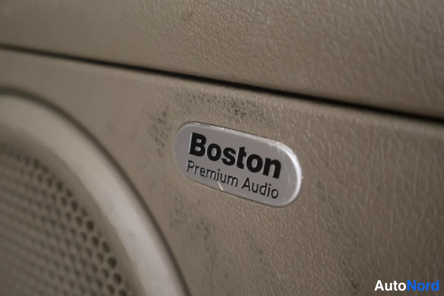 Yksityiskohta: Sisätilakuvan yksityiskohta: kaiuttimen kehyksessä Boston Premium Audio -merkintä.