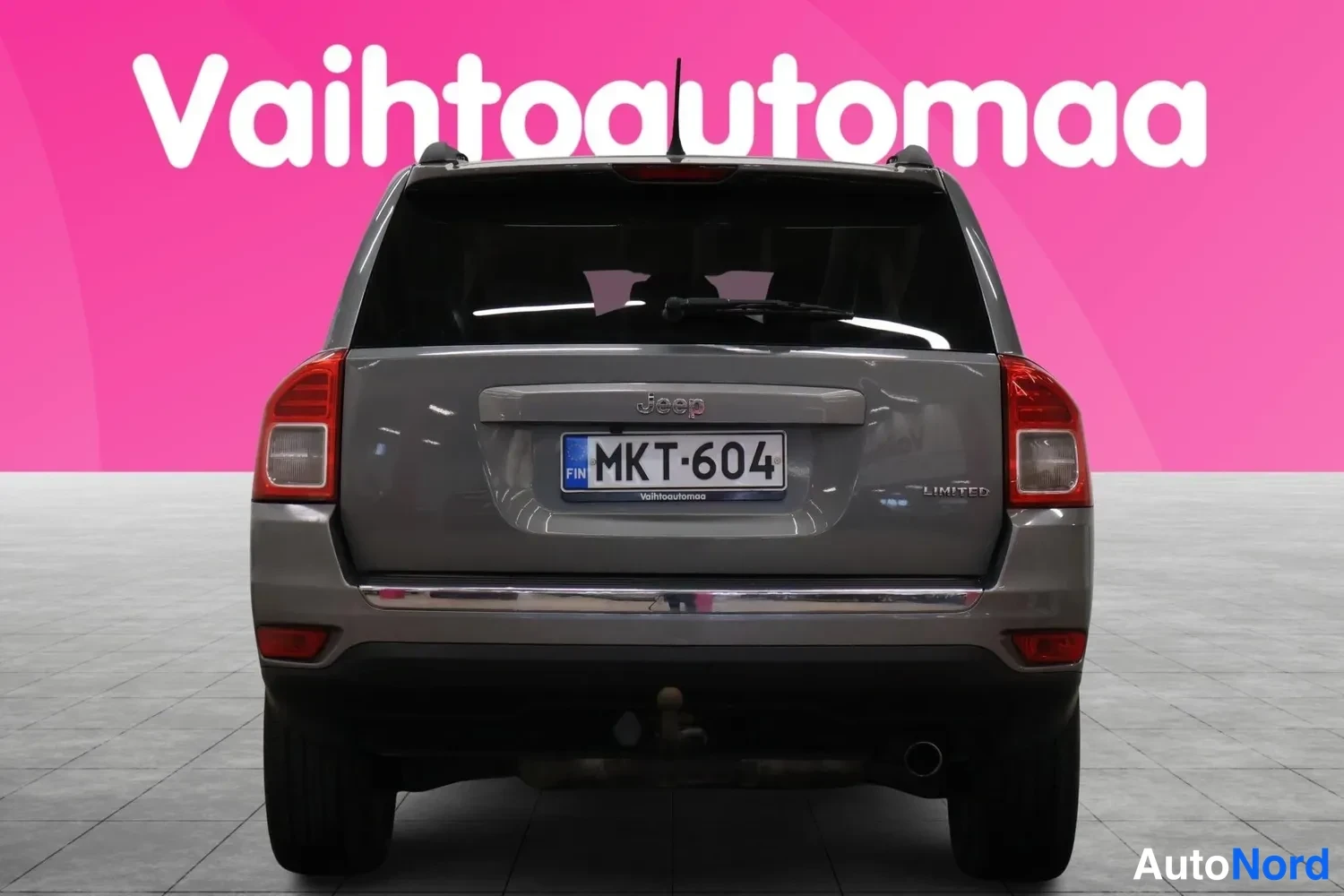 Takaa: Auton takaosa suoraan takaa, tummanharmaa Jeep Compass, rekisterikilpi, LIMITED-merkintä.