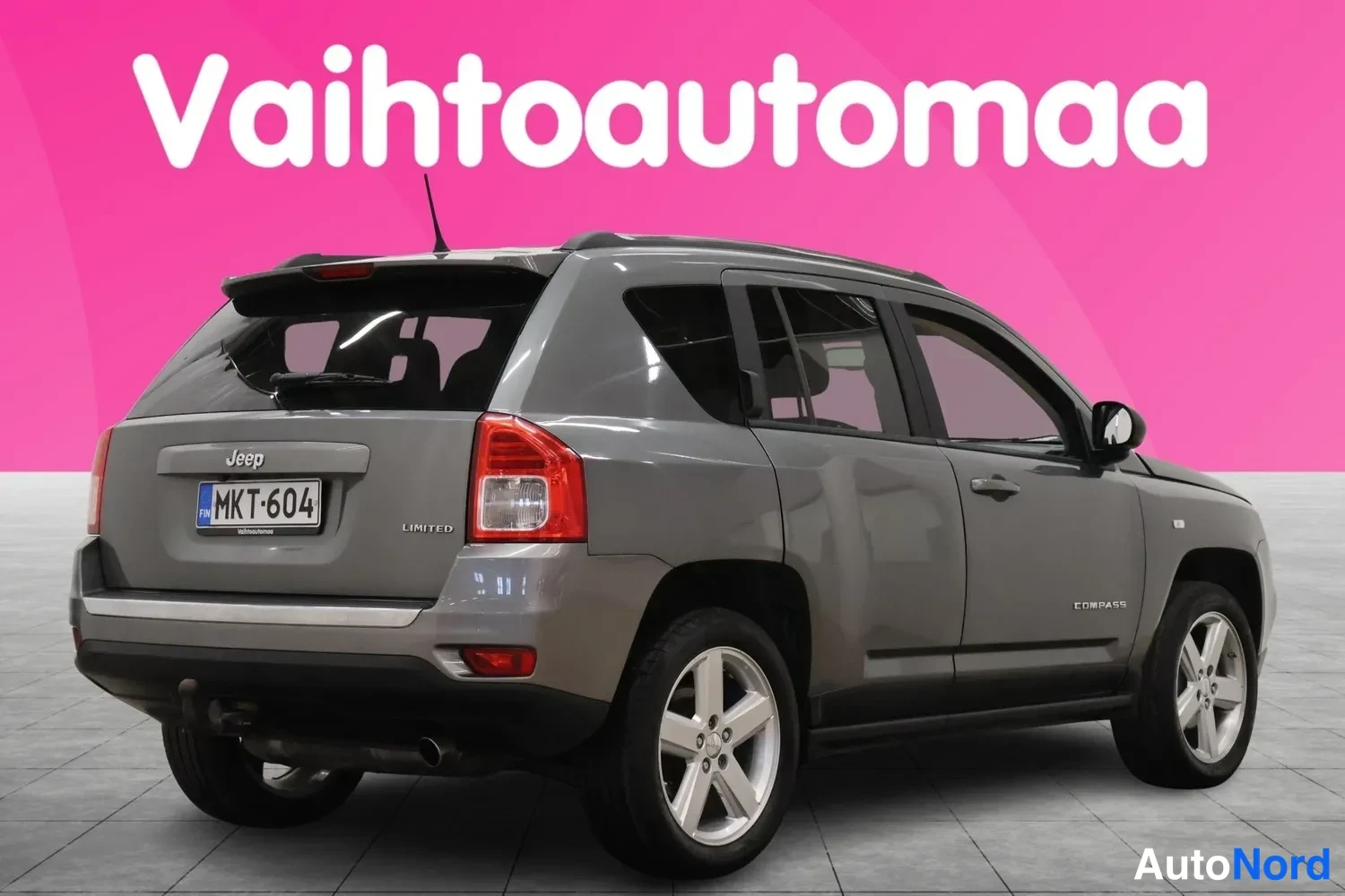 Takaviisto: Auton taka­kulma oikealta, tummanharmaa Jeep Compass, rekisterikilpi, LIMITED-merkintä.