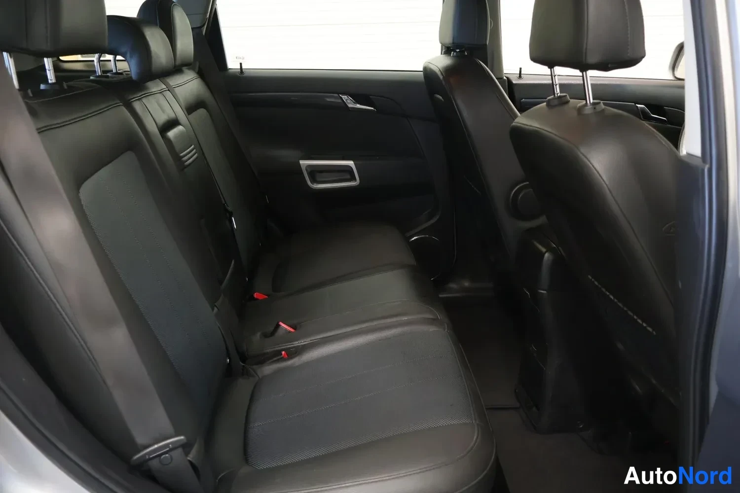 Muu: Opel Antaran takapenkkIä ja tavaratilan selkänojia mustalla nahalla, istuimet tyhjänä.