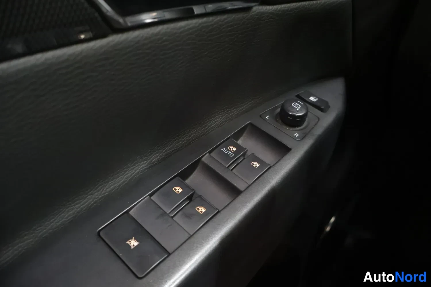 Muu: Ovenikkunan sähköikkunanostinten paneeli AUTO-napilla, peilinsäädin L/R-merkeillä ja lukituspainike.