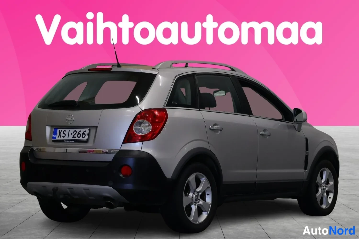 Takaviisto: Hopeanharmaa Opel Antara takaa sivulta kuvattuna, rekisterikilpi, kattokaiteet ja kohotettu takaovi.