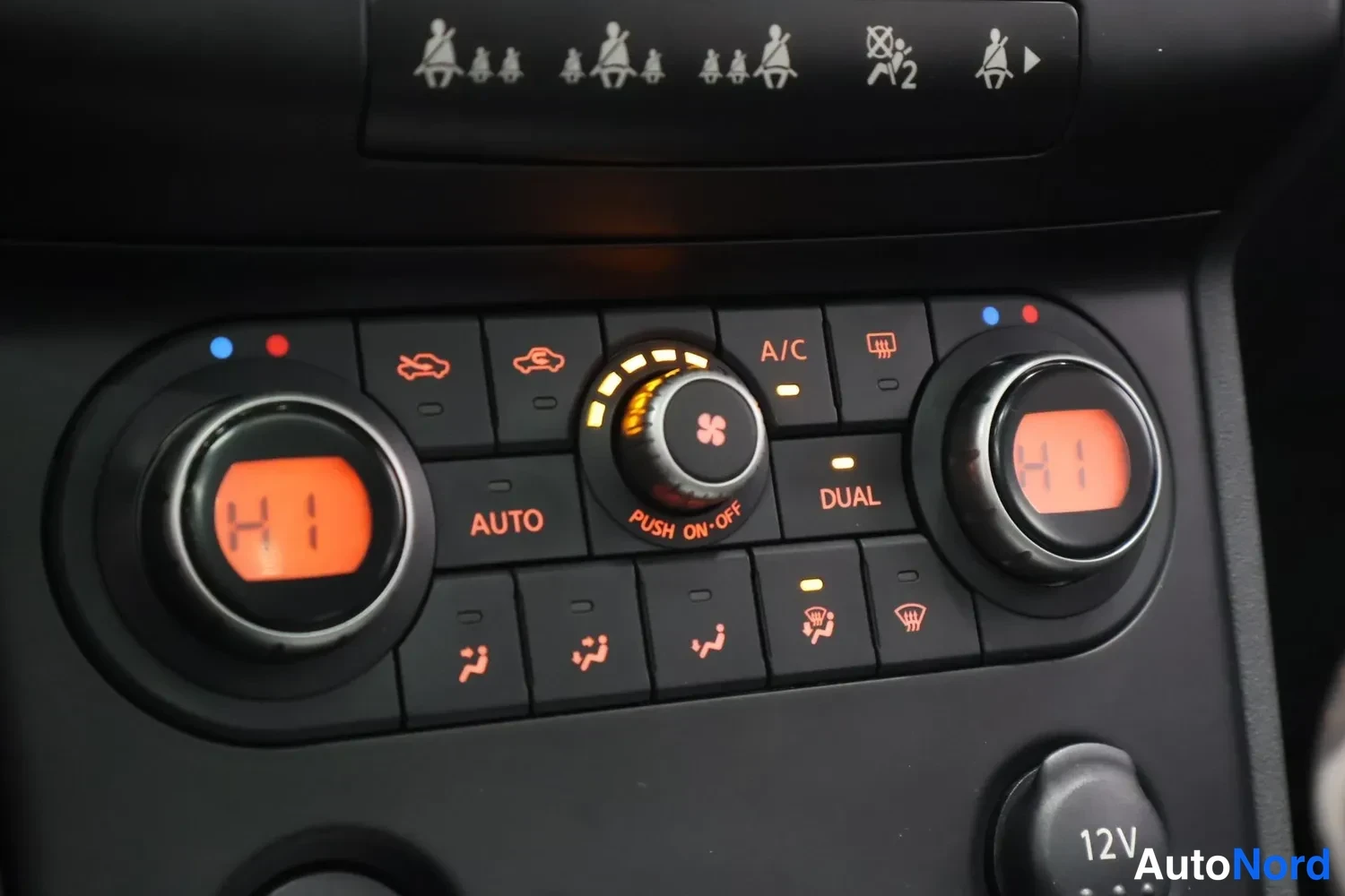 Muu: Kaksivyöhykkeinen automaattilmastoinnin ohjainpaneeli: molempien säätöjen näytöt näyttävät Hi:ä, painikkeet AUTO, DUAL, A/C ja 12V-pistorasian kansi.