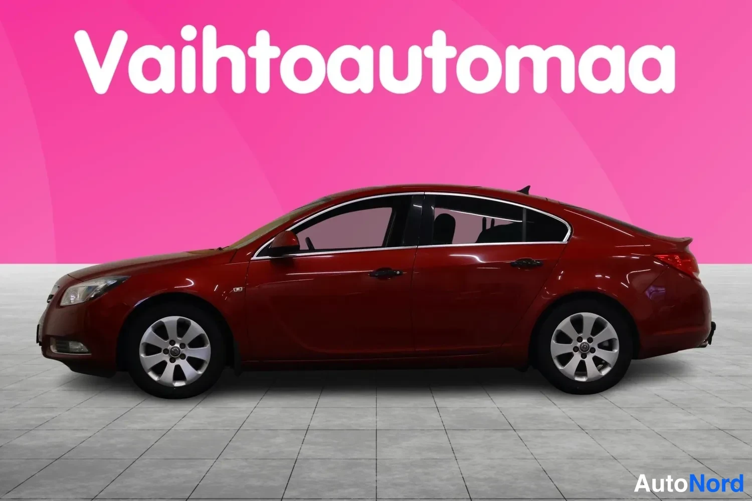 Sivulta: Punaisen Opel Insignia -henkilöauton vasen kylki sivusta kuvattuna.