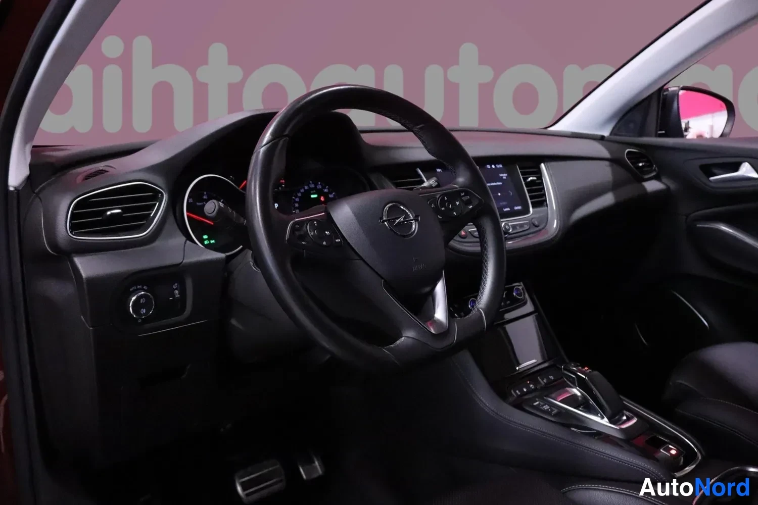 Yksityiskohta: Ohjaamo näkyy ohjauspyörästä mittaristoon ja keskikonsoliin; Opel-merkki ohjauspyörässä, kosketusnäyttö ja automaattivaihteen valitsin näkyvät.