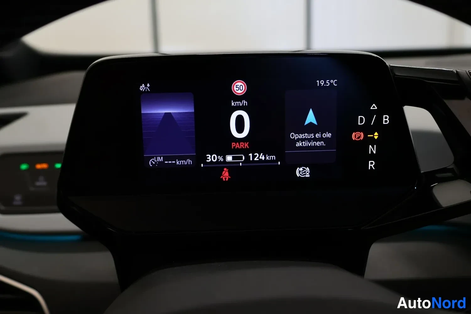 Yksityiskohta: Auton kojelaudan mittarinäyttö: nopeus 0 km/h, PARK, akun varaus 30 % ja kantama 124 km, ulkolämpötila 19,5 °C sekä teksti 'Opastus ei ole aktiivinen.'