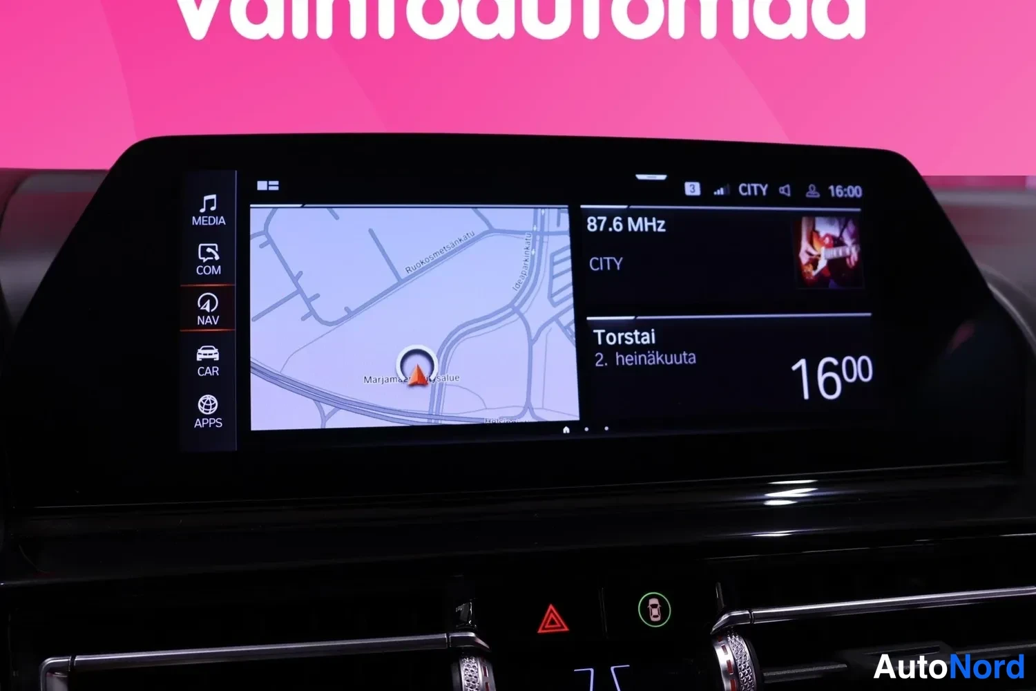Muu: Keskistöön konsolin infotainment-näyttö näyttää navigointikartan ja radiokanavan CITY 87.6 MHz.