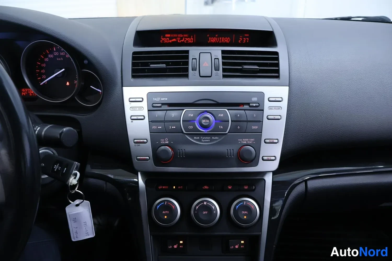 Muu: Kojelauta ja keskikonsoli: radioluuri CD-soittimella, ilmastointilaitteen AUTO/DUAL-säätimet ja näytöllä teksti JARRITAD.