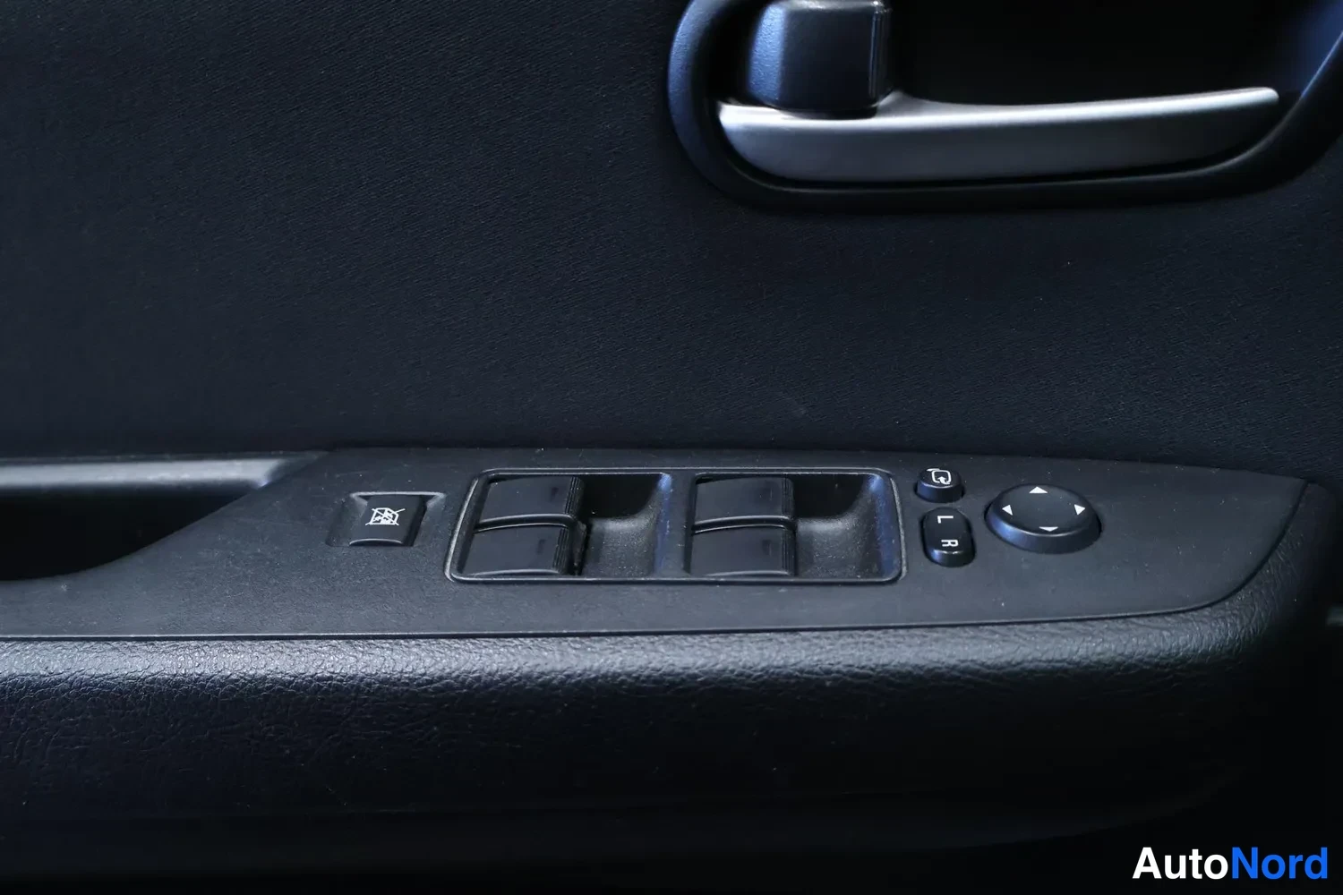 Yksityiskohta: Mazda 6:n oven sisäpaneelin ikkunoiden sähkötoimintojen painikkeet, peilien L-R-säädin ja ohjaustapin lukituksen merkkivalo.