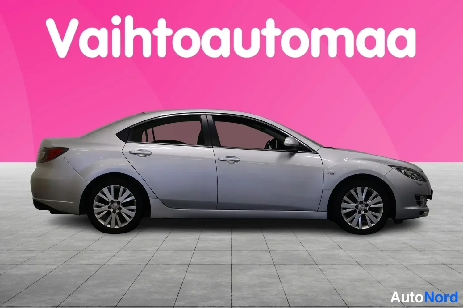 Etuviisto, nokka oikealle: Hopeanharmaan Mazda 6 -sedan sivuprofiili, keula hieman oikealle kääntyneenä.