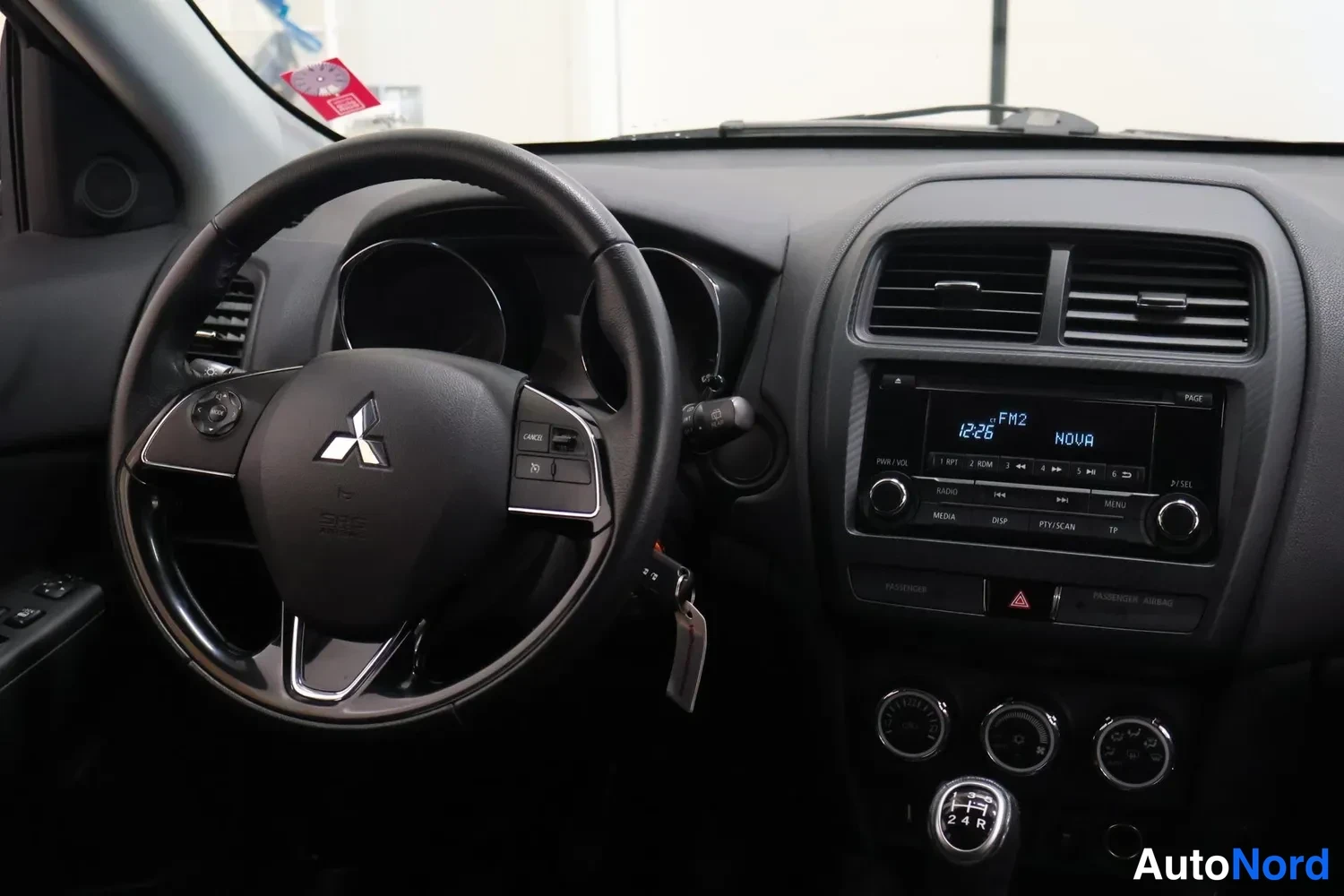 Muu: Ohjaamo vasemmalta kuvattuna: Mitsubishi-ohjauspyörä, radio-näyttö ja vaihtajan kahva näkyvät.