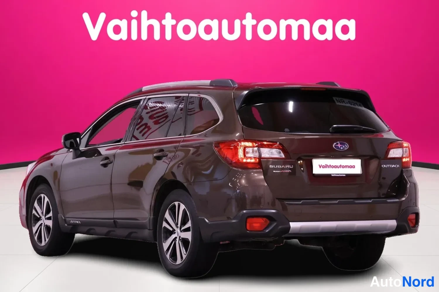 Takaviisto: Subaru Outback takakulma vasemmalta: tummanruskea farmarikori, punaiset takavalot sekä SUBARU- ja OUTBACK-tekstit takaluukussa.