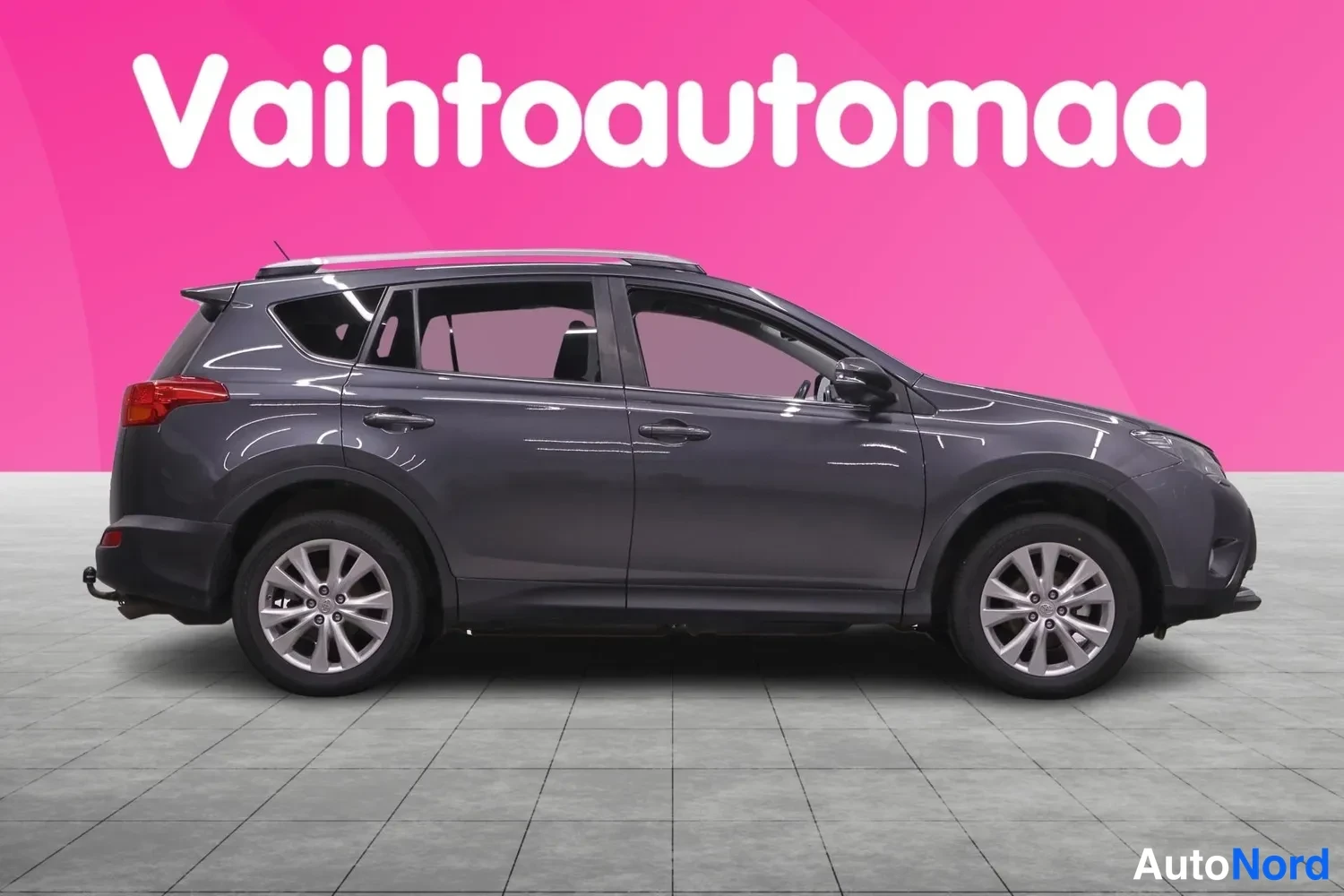 Sivulta: Auton sivukuva: tummanharmaan Toyota RAV4:n vasen sivu, hopeiset peltivanteet ja kattokaiteet näkyvät.