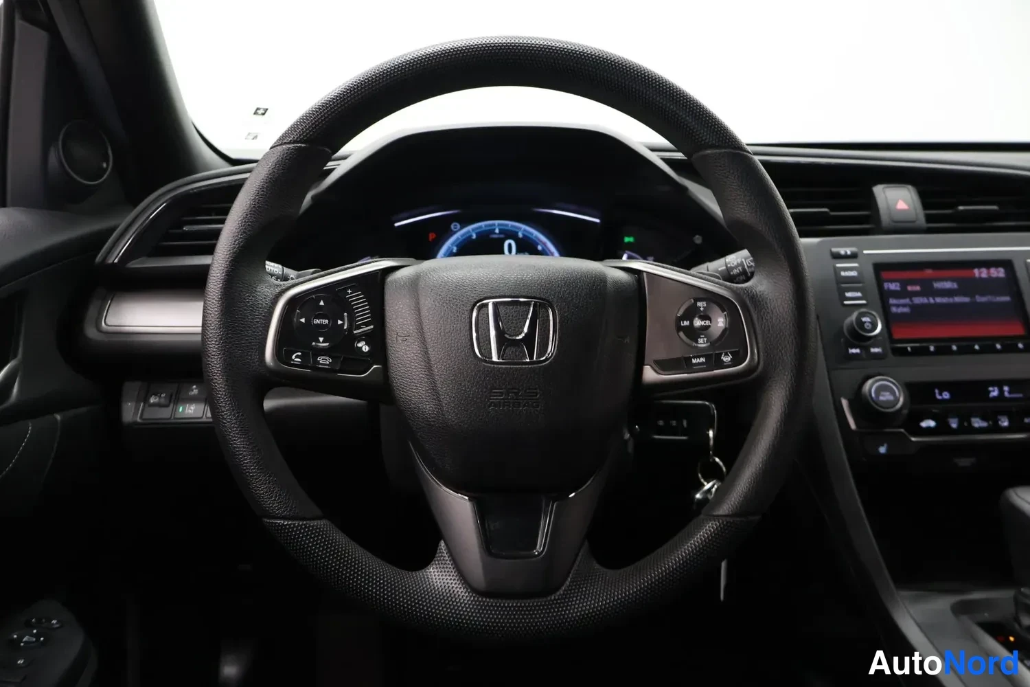 Muu: Ohjauspyörä ja kojelauta Honda Civicin sisältä: mittaristot, keskikonsolin infotainment-näyttö ja avain lukituksessa.