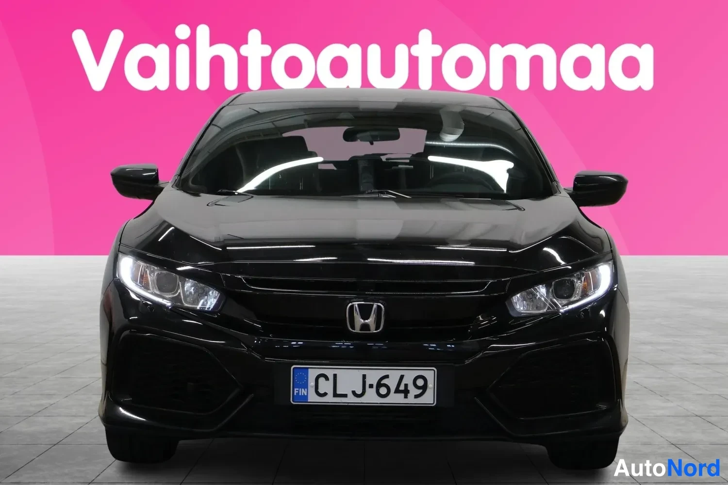 Edestä: Musta Honda Civic suoraan edestäpäin, Honda-merkki ja rekisterikilpi näkyvät.