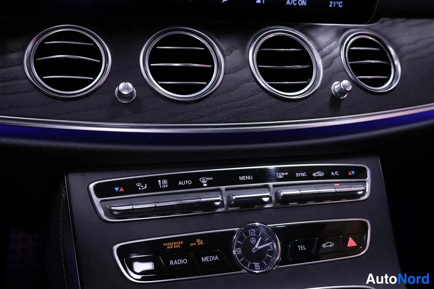 Yksityiskohta: Keskikonsolin lähikuva: ilmastointilaitteet, nappirivi (AUTO, MENU, SYNC, A/C), kello sekä RADIO- ja MEDIA-napit.