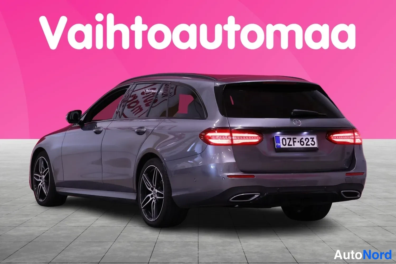 Takaviisto: Mercedes-Benz E 300d -farmari takaviistosta, harmaa kori, neonesuuntajuovat takavalot ja rekisterikilpi.