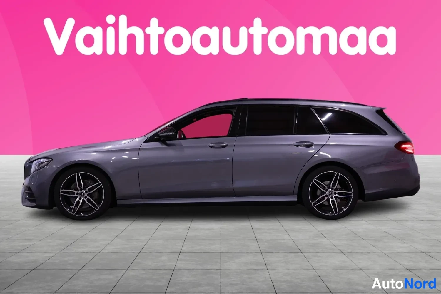 Sivulta: Mercedes-Benz E 300d -farmari sivulta, harmaa kori ja mustat moni}sätekäyttöiset kevytmetallivanteet.