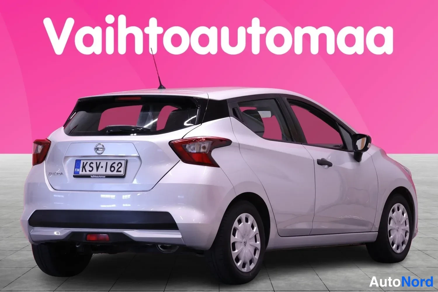 Takaviisto: Nissan Micran takaosa ja oikea kylki näkyvät kolmannes kulmasta; auto on hopeanvalkoinen, rekisterikilpi.