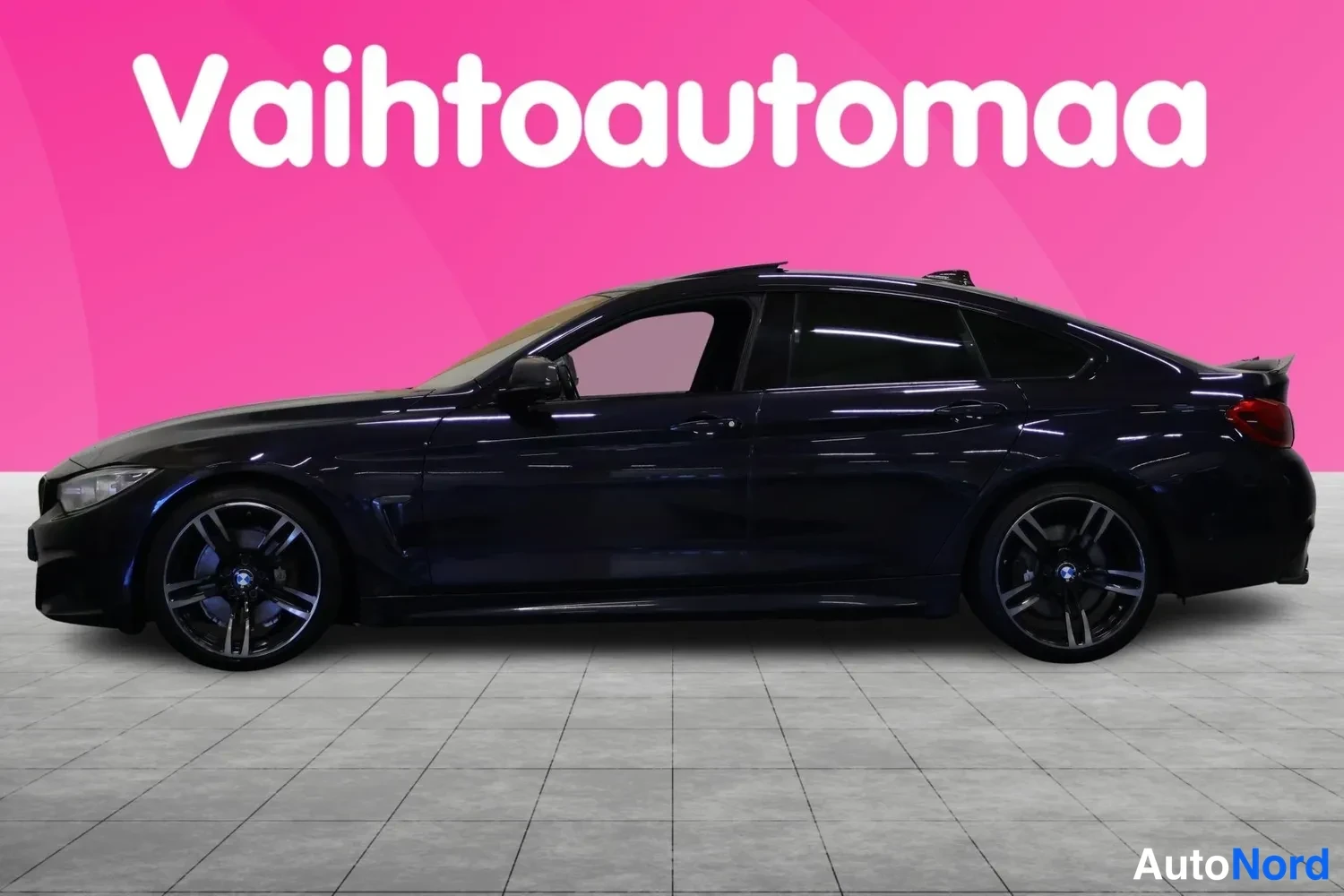 Sivulta: Tummansininen BMW-neliovi kuvattu täsmälleen sivusta, molemmat pyörät ja ovenlinjat näkyvät.