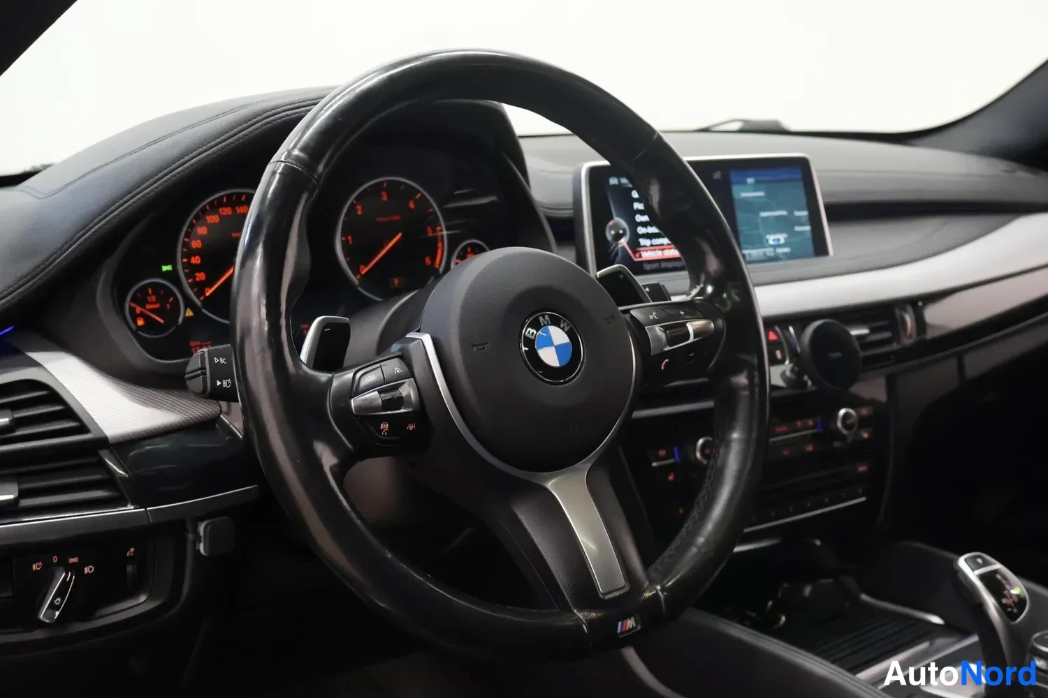 Muu: BMW:n ohjauspyörä ja kojelauta: analogiset mittarit ja keskelle sijoitettu kosketusnäyttö.