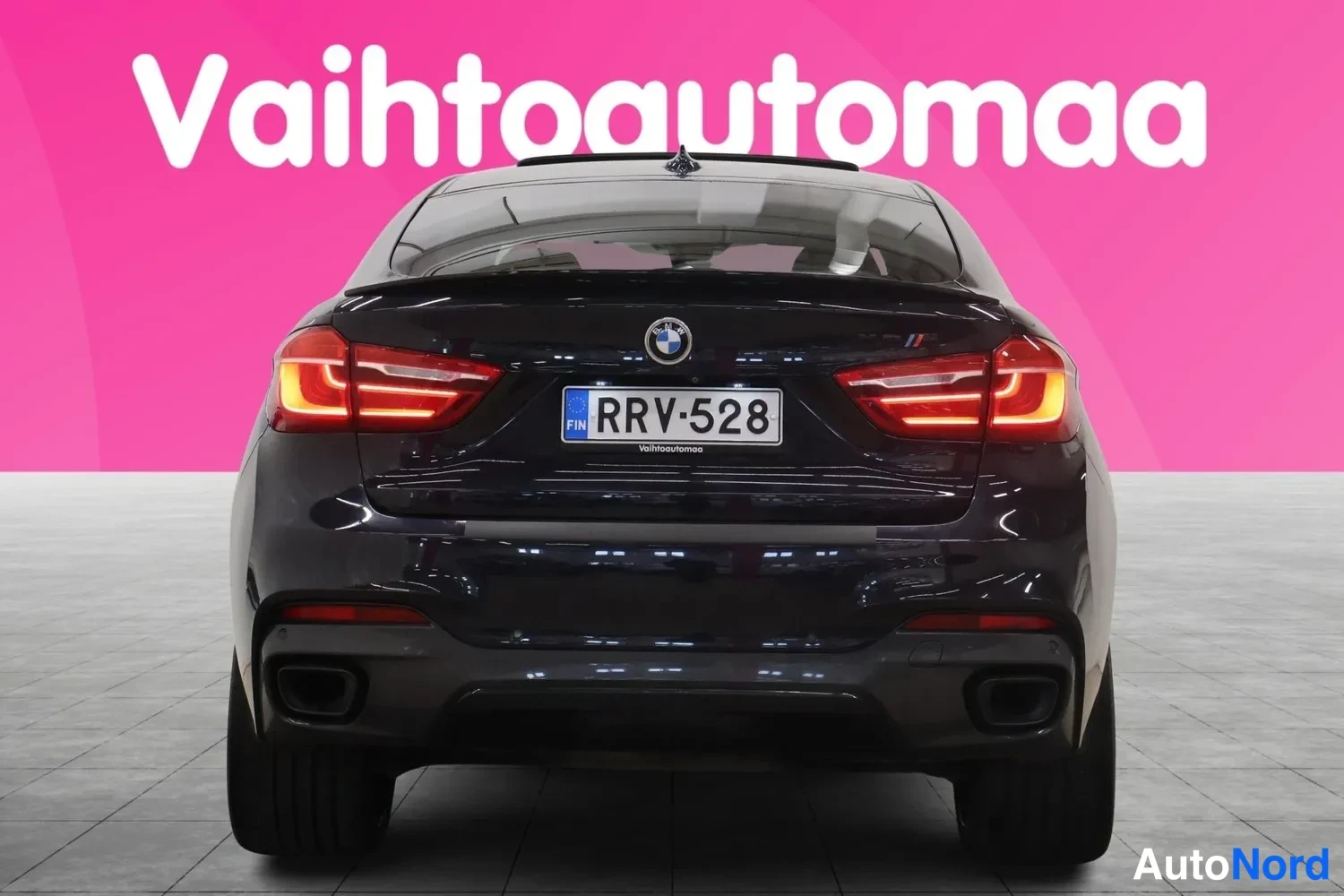 Takaa: Auton takaosa suoraan takaa, kaksiosaiset pakoputket ja rekisteritunnus.