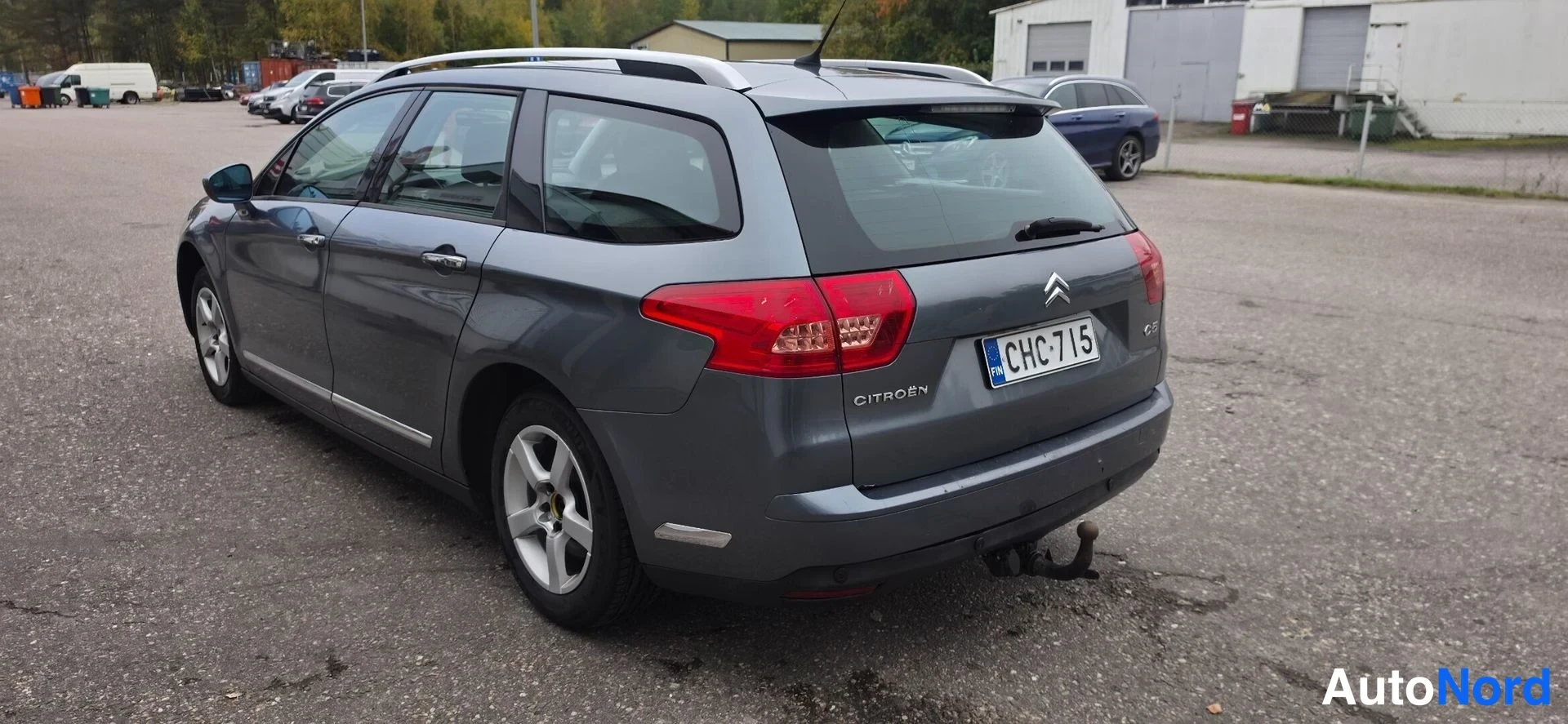 Takaviisto: Citroën C5 -farmari takaosasta vasemmalta, punaiset takavalot ja vetokoukku näkyvät, rekki.
