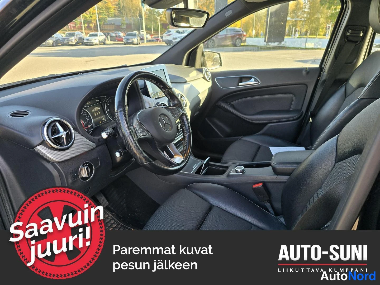 Muu: Musta Mercedes-Benz B:n ohjaamo kuljettajan puolelta: ohjauspyörä, kojelauta ja penkit näkyvät.