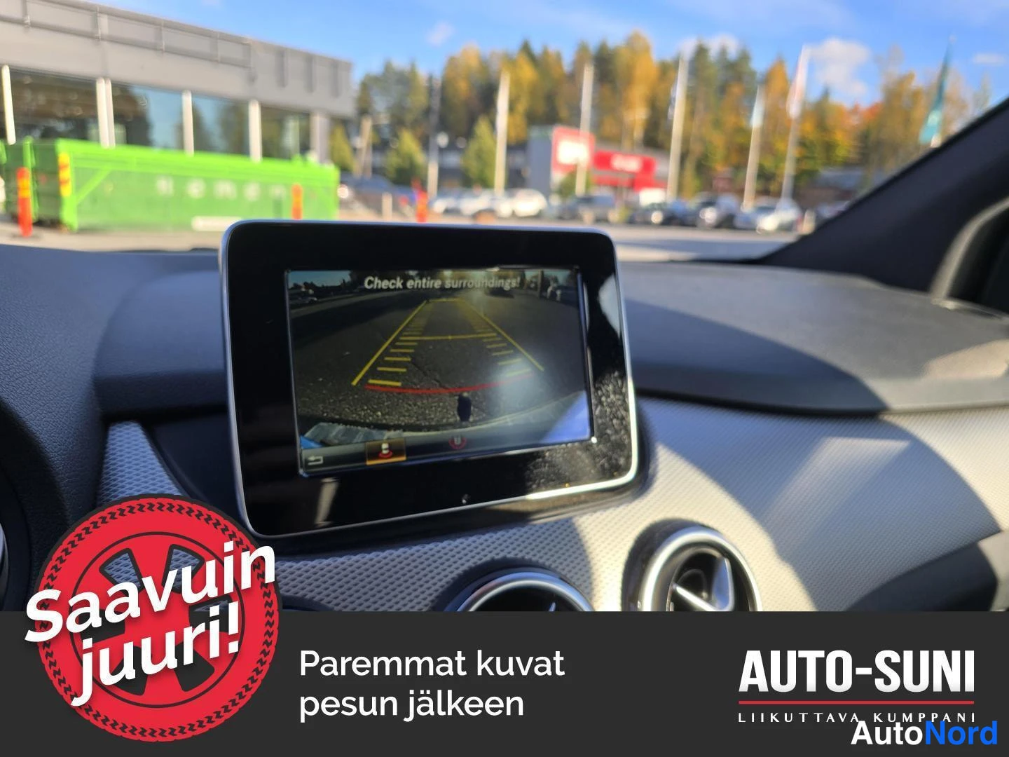Muu: Kojelaudan näyttö, jossa näkyy peruutuskameran kuva tekstillä 'Check entire surroundings!'