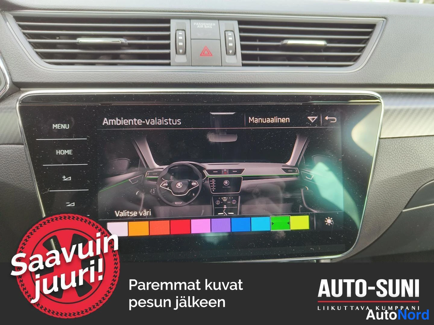 Muu: Kojelaudan keskeltä näkyy infotainment-näyttö, jossa on auki Ambiente-valaistus -asetusruutu väripalkilla