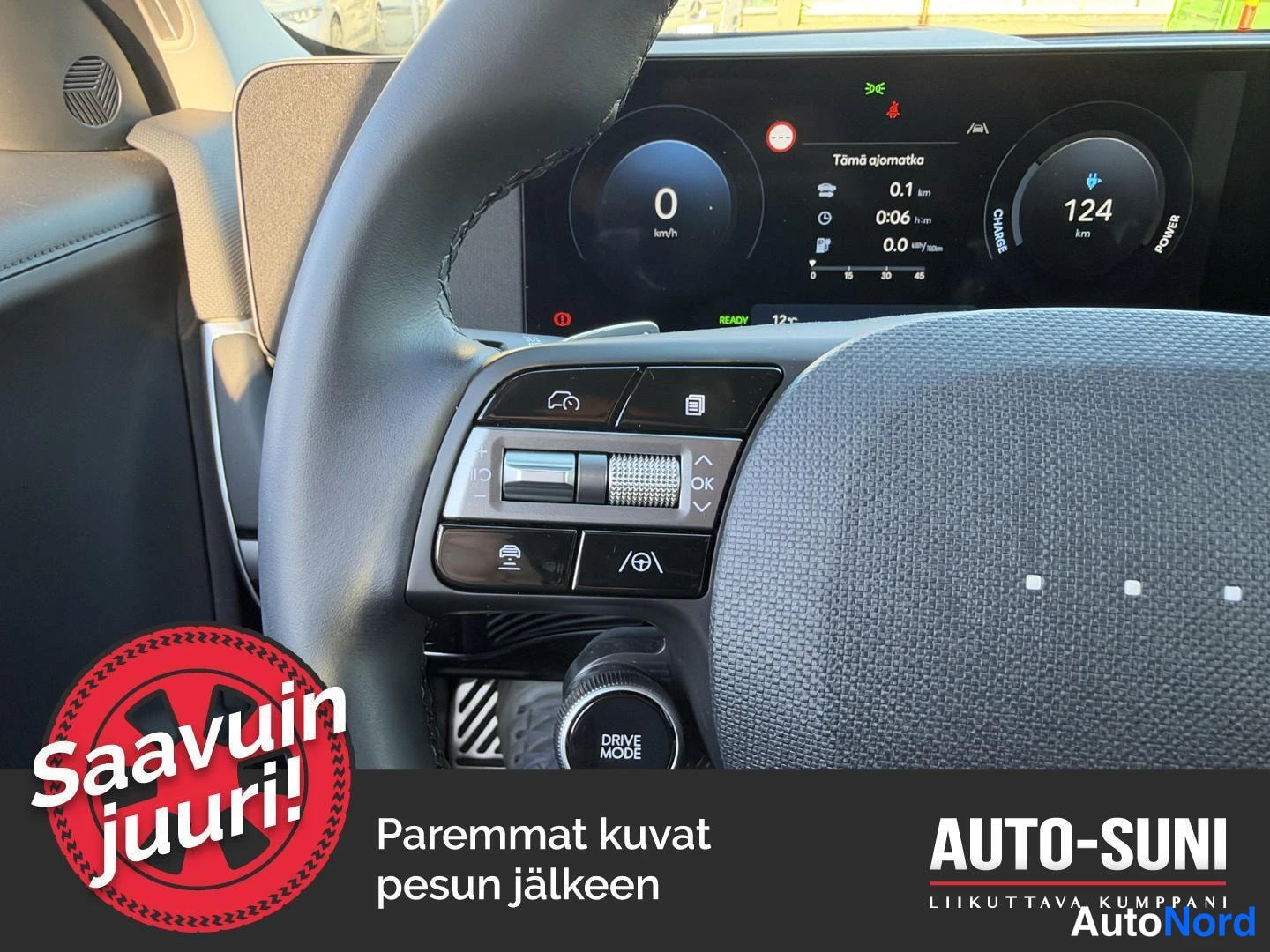 Muu: Hyundai IONIQ 5:n ohjauspyörän vasemmat säätimet ja DRIVE MODE -nappi, taustalla kuljettajan näyttö.
