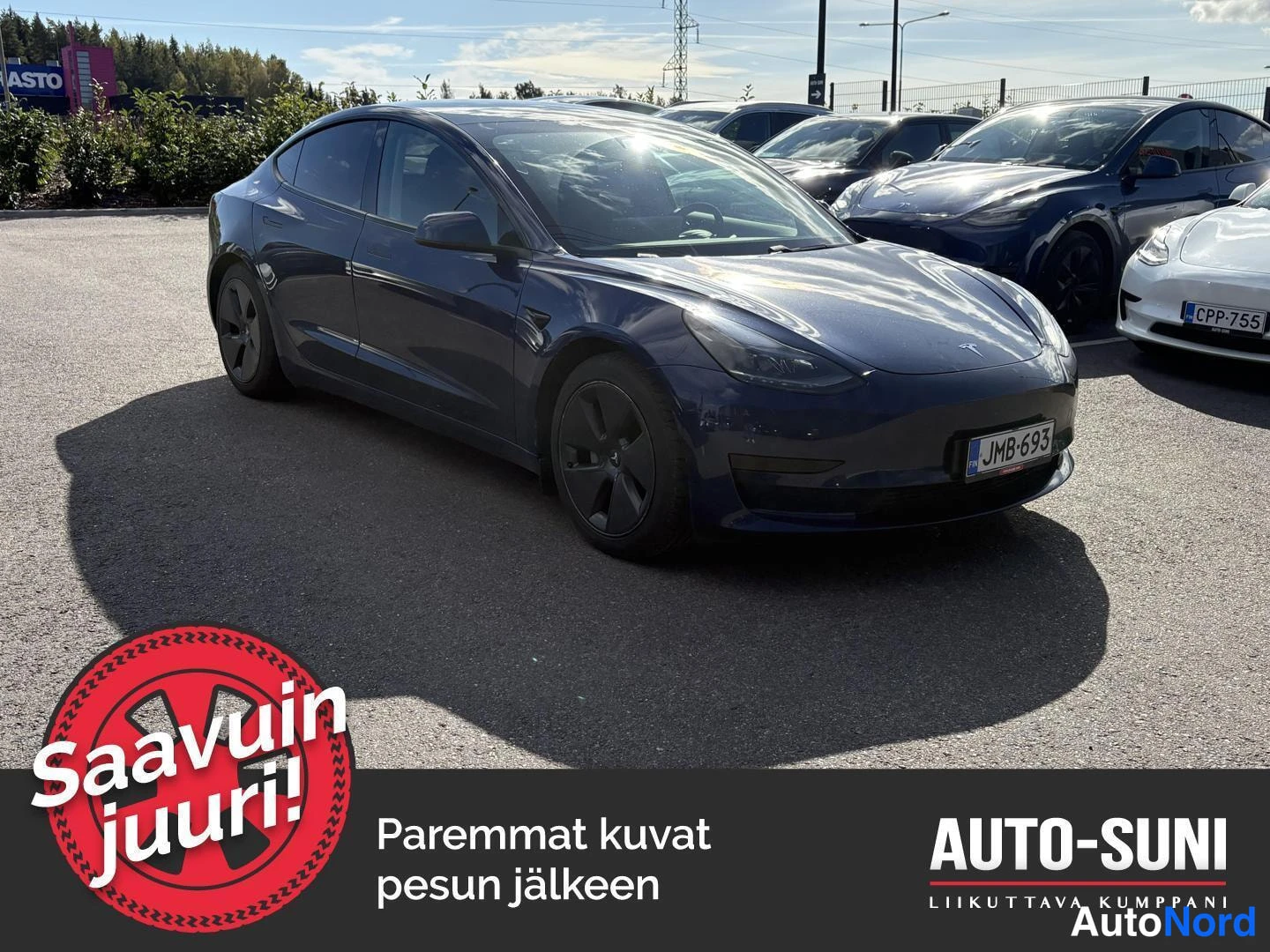 Etuviisto, nokka oikealle: Sininen Tesla Model 3 etuviistöstä oikealta, rekisteri, parkkihallilla.
