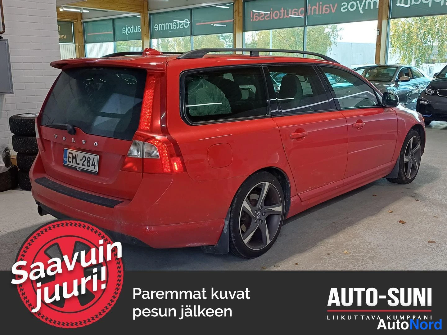 Takaviisto: Punainen farmariauto takaviistosta, perä ja oikea kylki näkyvissä, takavalo, nostoluukku ja kattokaiteet sisätiloissa.