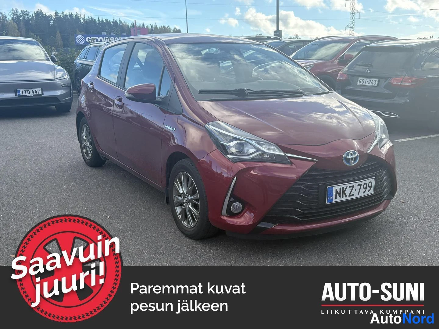Etuviisto, nokka oikealle: Tummanpunainen Toyota Yaris -henkilöauto kuvattu edestä vasemmalta päin, rekisterikilpi.