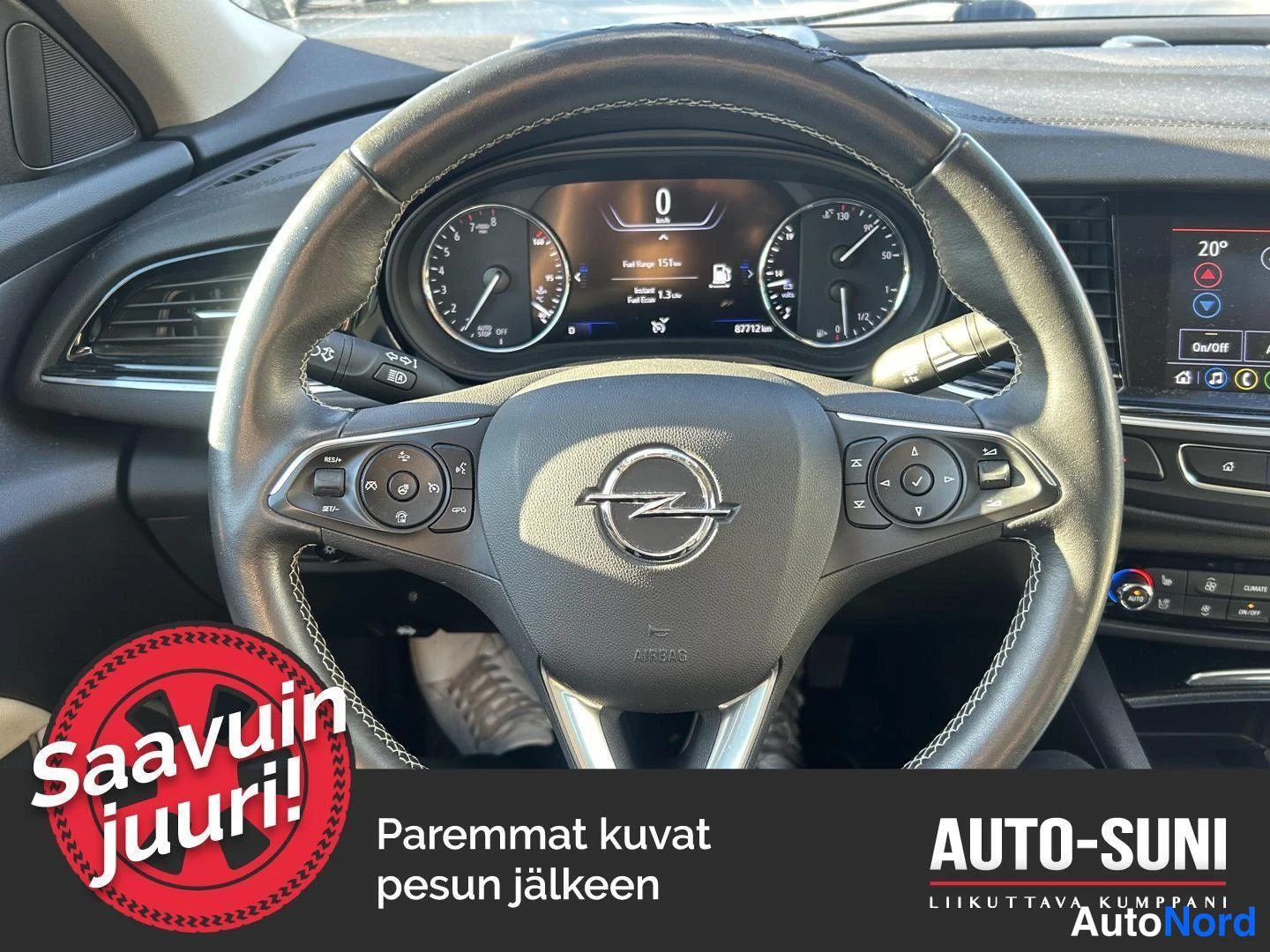 Muu: Opel Insignian ohjaamon näkymä: multimediapöytäkirja, kuljettajan ohjauspyörä ja mittaristo.