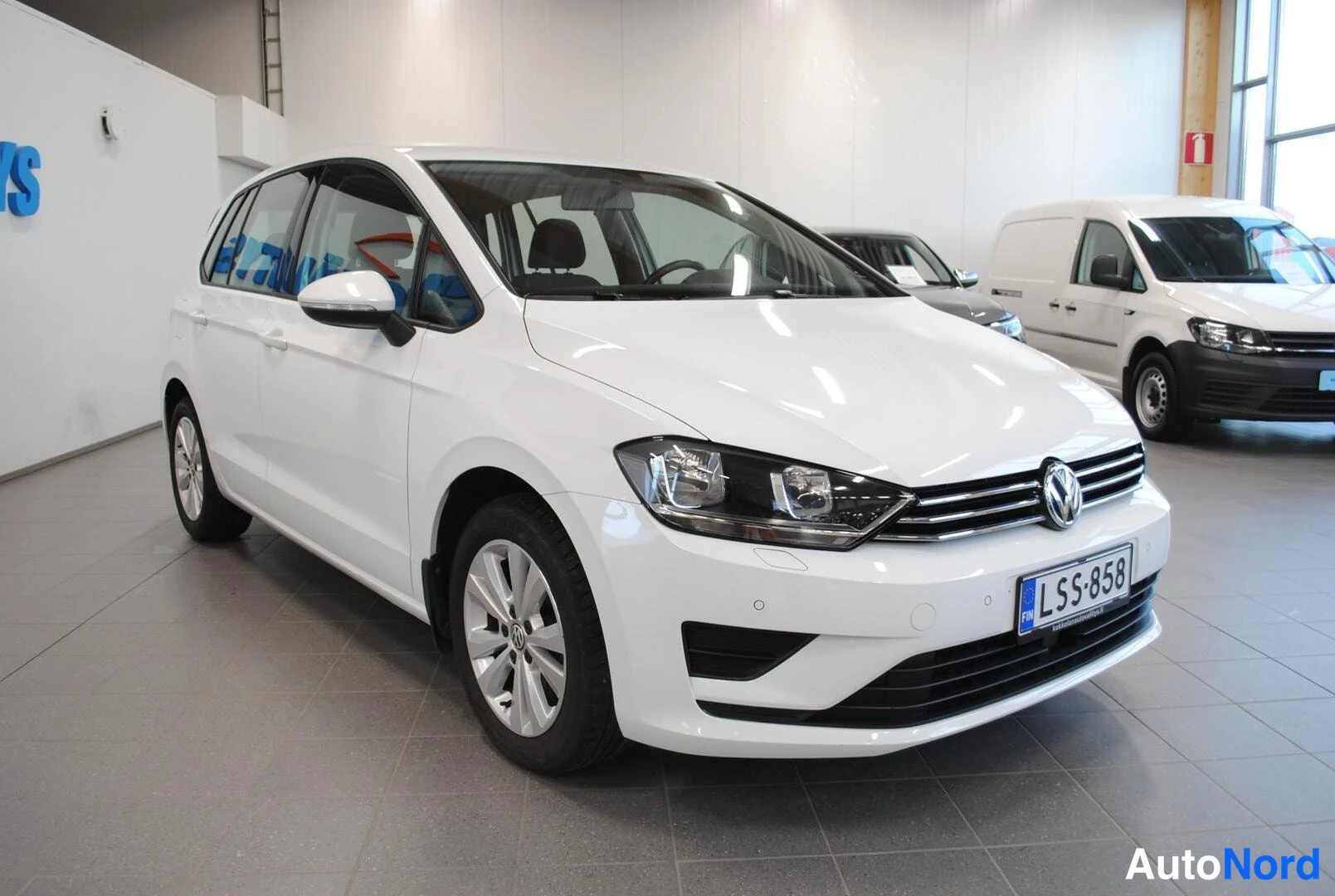 Etuviisto, nokka oikealle: Volkswagen Golf Sportsvan etu kolmannes oikea, valkoinen