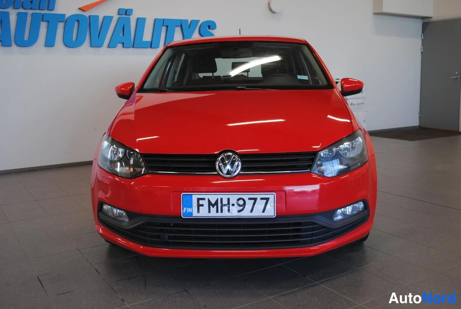 Edestä: Punaisen Volkswagen Polon etunäkymä suoraan edestä, rekisteritunnus.