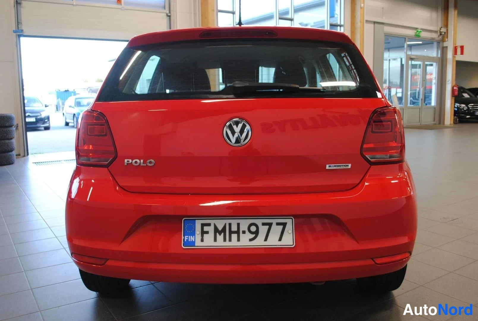 Takaa: Punaisen Volkswagen Polon takaosa suoraan takaa, rekisteritunnus, POLO-merkintä takaluukussa.