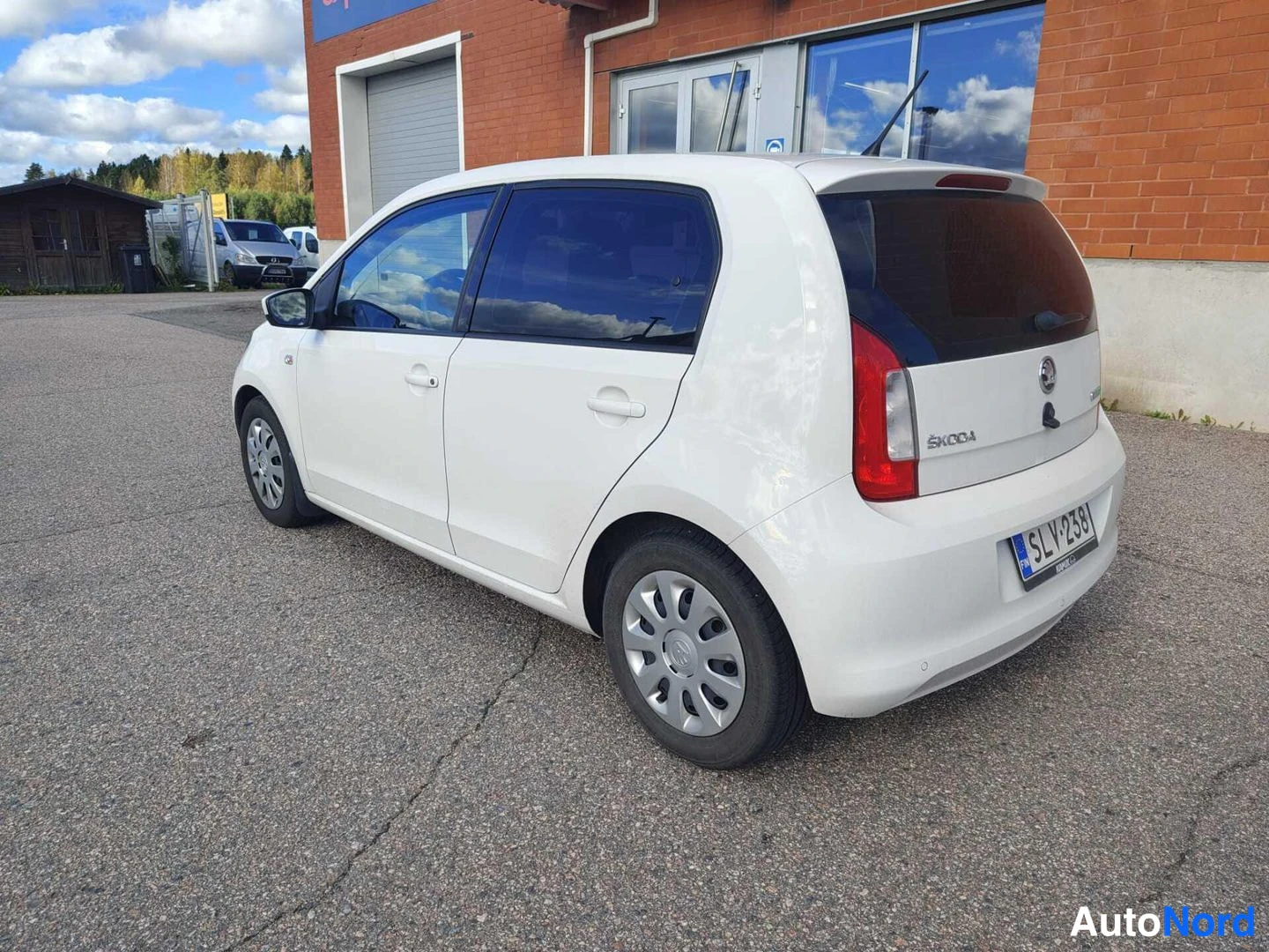 Takaviisto: Valkoinen Skoda Citigo kuvattuna takaa oikealta kolmivirtauksesta. Takavalo, ŠKODA-merkintä ja rekisterikilpi näkyvät. Takavalaistussa tilassa auton oikea kylki