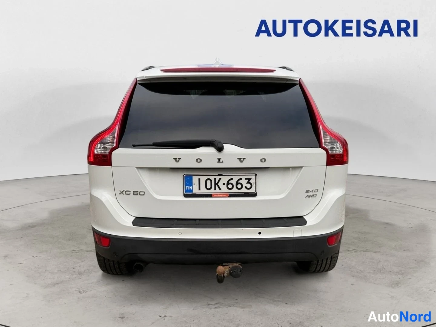 Takaa: Valkoinen Volvo XC60 takaa kuvattuna, rekisterikilpi 10K-663, vetokoulu takapuskurissa.