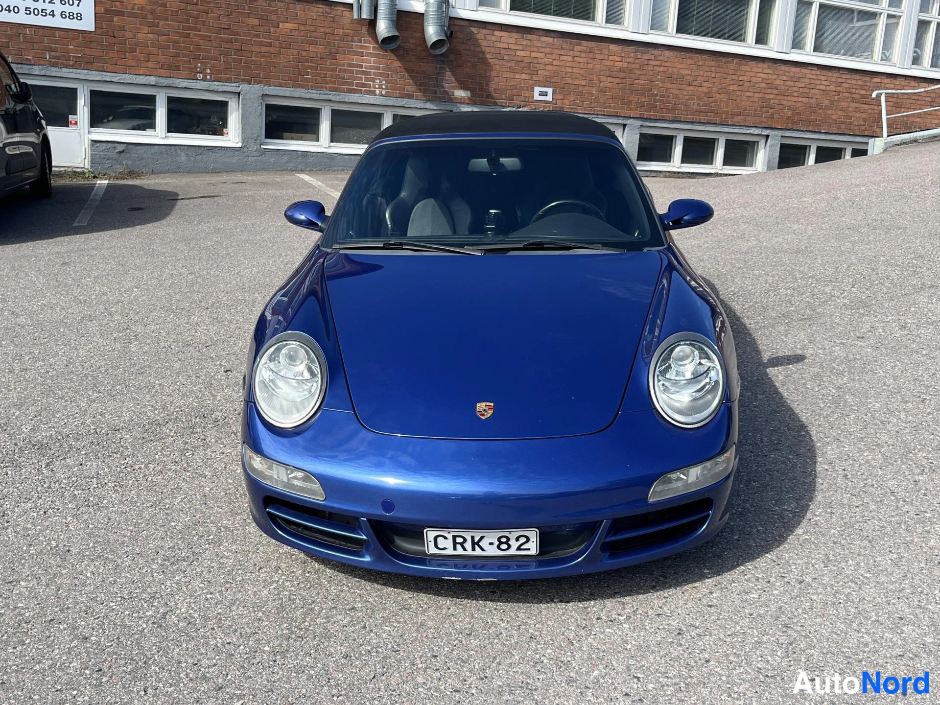 Edestä: Etukuva sinisestä Porschesta rekisterimerkki, katto ylhäällä.